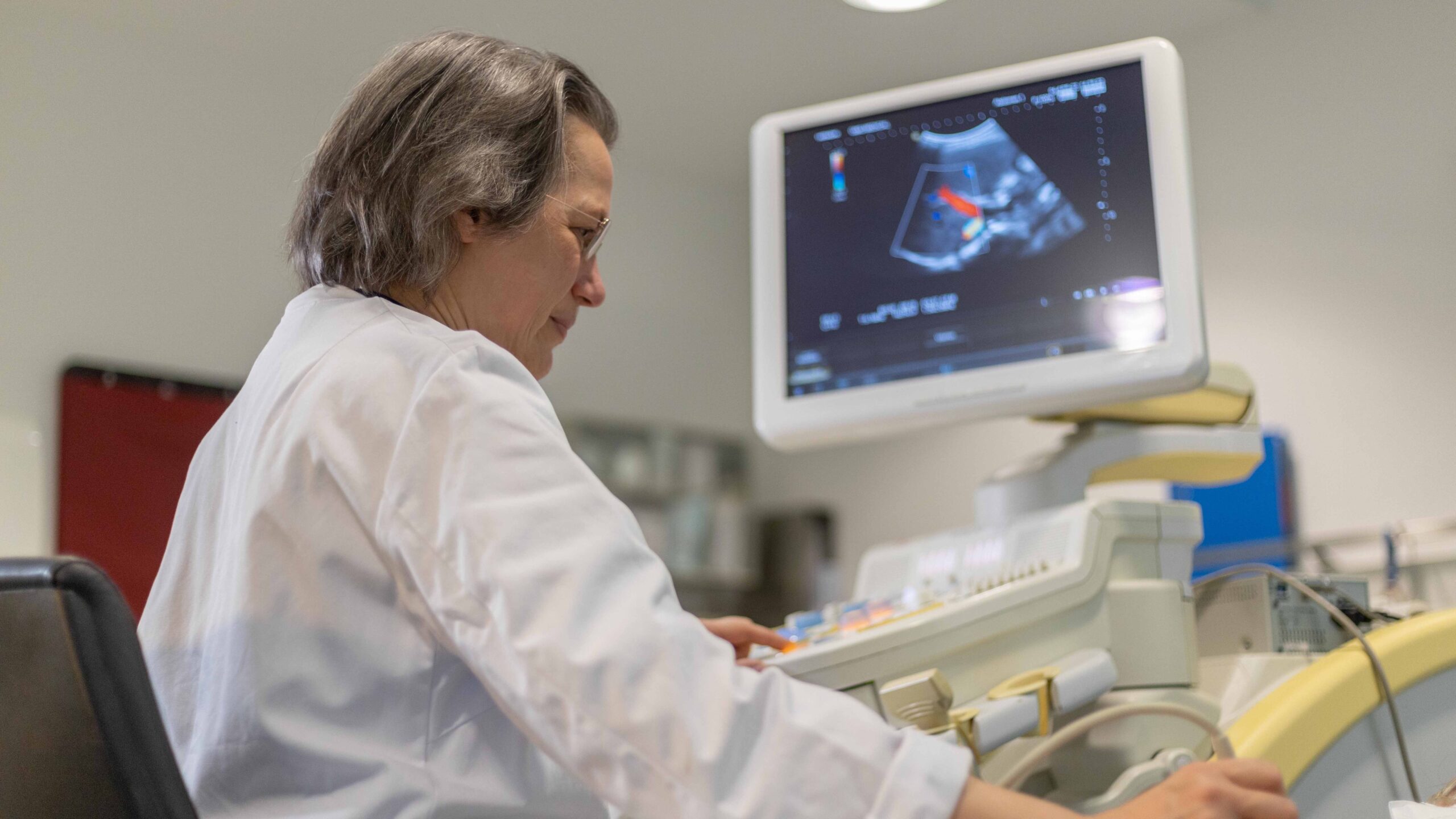 Ärztin untersucht Patienten mit Ultraschall